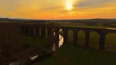 Iconic demiryolu viyaolkü gün ışığının yumuşak ışıklarıyla aydınlanıyor. Doğanın kalbinde eski demiryolu viyaolkü, gün batımında yukarıdan ele geçirildi. Tarihsel alanlar, ünlü bölge, canlı doğa yoluyla ulaşım yapısı