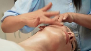 Rahatlamak için alnına hafif vuruşlar uyguluyor. Hafif parmak uçları gerginliği azaltmaya ve sükuneti arttırmaya yardımcı olur. Nazik hareketler dolaşımı teşvik eder ve cilt rengini parlatır. Hassas masaj huzurlu ve dengeli devleti teşvik eder.