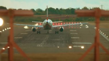 Uçak pistte hızlanıyor motorlar ısı sisi ve seyrüsefer ışıkları parlıyor. Yolcu uçakları uçak pistinde türbinlerle hız yapıyor çarpıtma ve pist lambaları parlıyor. Ticari jet motorlarla kalkış pistinde ilerliyor.