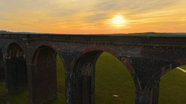 Viyadük, gece karanlığında parlıyor. Eski demiryolu viyaoluğunun altındaki sakin vadi, hava perspektifinden çekildi. Tarihi bir yer, çarpıcı manzaranın içinden geçen ulaşım ağı.