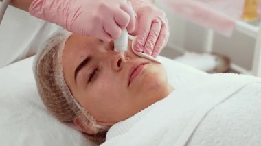 Güzellik uzmanı kadın güzellik kliniğinde su mikro dermabrüksiyon cihazı kullanıyor. Hasta yenilenmiş cilt için hafif bir deri soyma tedavisi görüyor. Teknikler su içmeyi ve derin temizliği teşvik eder.