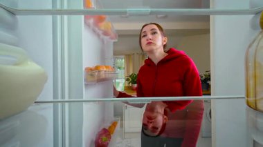 Boş buzdolabını açan ve yemek ararken kafasını kaşıyan kadın buzdolabının içini görüyor. Kafası karışmış ve biraz hayal kırıklığına uğramış genç bir kadın yiyecek eksikliğinin farkına varıyor. Bir kadın hissederken raflara bakıyor.