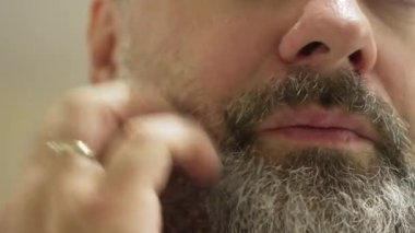 Elinle sakal çiziyorsun. Parmaklarınla sakal ovuyorsun. Kaşınan çene bölgesi sakala dokunuyor.