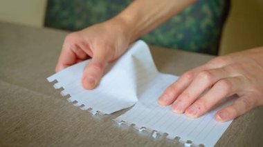 Psikolojik sorunları ve depresyonu yansıtan kağıtları parçalara ayırmak. Sayfayı parçalara ayırmak duygusal mücadeleyi sembolize ediyor. Not defterini yırtık parçalara ayırmak zihinsel sorunları iletiyor.