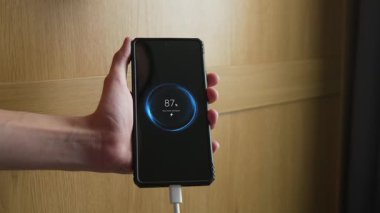 Hızlanırken cep telefonuna cihaz yüklüyorum. Akü seviyesi artarken akıllı telefon kavrama cihazına güç veriliyor. El bilgisayarı destekleyici telefonu şarj ederken şarj etme yüzdesi artıyor