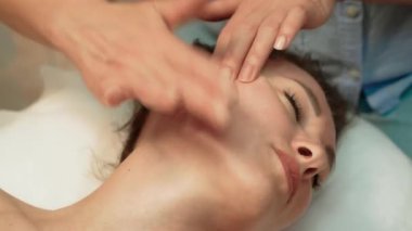Yenilenme ve rahatlama için yüz masajı. Masaj terapisti tarafından yapılan yüz bakımı tedavisi. Sağlık vücut masajı ve yüz spa konsepti. Spada masaj prosedürü