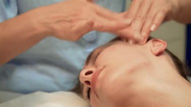 Rahatlamak ve gençleşmek için müşteriye masaj yapmak. Enerji dizilimi için yüz bölgesini nazik darbelerle tedavi ediyorum. Ruhani uyumu arttırmak için yüz masajı yapıyorum. Bireysel olarak sakinleştirici yüz tedavisi uygulanıyor.