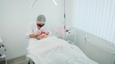 Kozmetik kliniğindeki kız hasta cilt bakımı ve siyah başlık aldırma tedavisi görüyor. Güzellik kliniğindeki kadın hasta cilt bakımı ve sivilce aldırma işlemi görüyor. Kozmetik Merkezi 'nde yüz bakımı ve siyah nokta temizliği gören bir kadın.