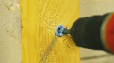 Matkapla tahta yüzeye vidalayacağım. Elektrikli aletle tahta tahtanın içine vida sokuyorum. El bilgisayarı matkabı kullanarak tahtanın içine donanım yerleştiriliyor. Sıkıştırılmış sürücüyü kullanarak tahta panele metal vida takmak