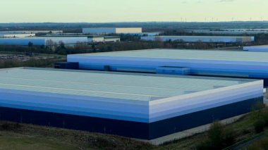 Sanayi bölgesindeki birçok depo binasının lojistik altyapısının havadan görüntüsü. Büyük ölçekli dağıtım merkezlerinin insansız hava aracı perspektifi depolama ve tedarik zinciri süreçlerini yönetir. Modern uçağın yüksek irtifa görünümü