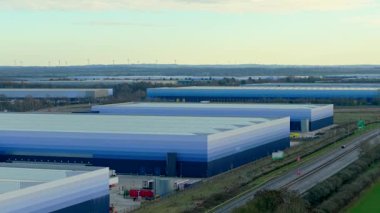 Büyük lojistik depoları otoyol yakınlarındaki sanayi bölgesinde genişliyor. Dağıtım merkezi nakliye ambarlarını koordine ediyor. Mal akışlarını kontrol ediyor. Sanayi tedarik zinciri altyapısı üretim lojistik operasyonlarını destekliyor