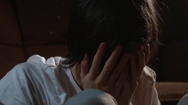 Ruh sağlığı, psikoloji ya da iyileşme terapisi duygusal mücadelede yüzünü kapatan genç bir adamı destekliyor. Sessiz uzayda oturan biri derin iç gerilimi yansıtıyor ve yönlendirilmeye ihtiyacı var. Saklanan ergen yüzü incinebilirlik ve özlem gösteriyor