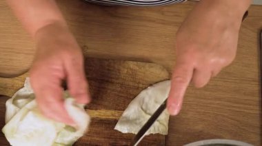 Ev yapımı dolma rulo için lahana yaprağı doğruyorum. Etli geleneksel golubtsy için sebze örtüsü hazırlıyorum. Ulusal mutfak yemeği için yeşil yaprak kesiyorum.