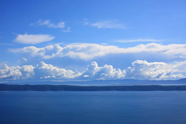 Blue sky with white clouds above the sea