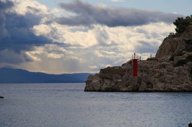 Mavi gökyüzü, denizin üstünde beyaz bulutlar