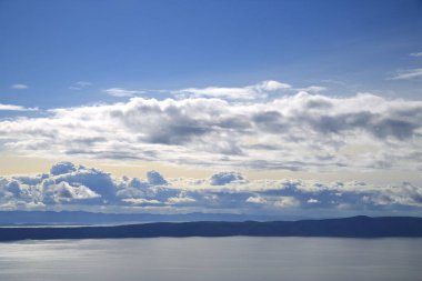 Hırvatistan 'da Adriyatik Denizi üzerindeki mavi gökyüzünde beyaz bulutlar