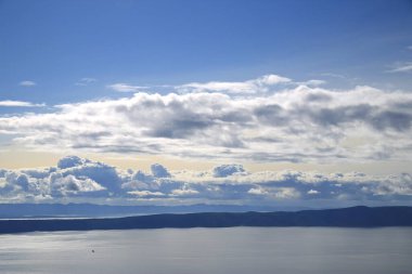 Hırvatistan 'da Adriyatik Denizi üzerindeki mavi gökyüzünde beyaz bulutlar