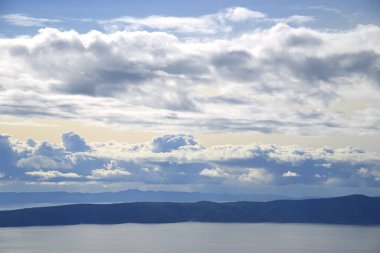Hırvatistan 'da Adriyatik Denizi üzerindeki mavi gökyüzünde beyaz bulutlar