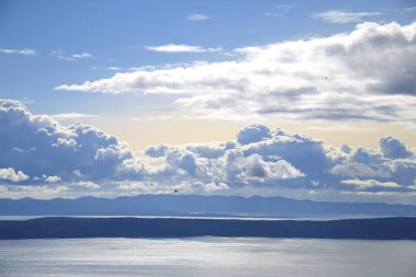Hırvatistan 'da Adriyatik Denizi üzerindeki mavi gökyüzünde beyaz bulutlar