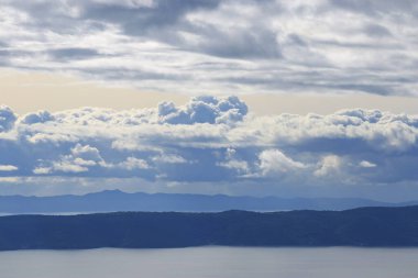 Hırvatistan 'da Adriyatik Denizi üzerindeki mavi gökyüzünde beyaz bulutlar