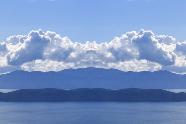 Hırvatistan 'da Adriyatik Denizi üzerindeki mavi gökyüzünde beyaz bulutlar