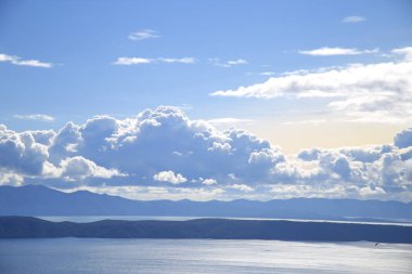 Hırvatistan 'da Adriyatik Denizi üzerindeki mavi gökyüzünde beyaz bulutlar