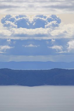 Hırvatistan 'da Adriyatik Denizi üzerindeki mavi gökyüzünde beyaz bulutlar