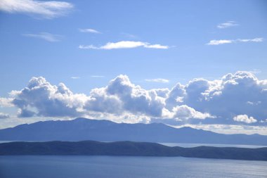 Hırvatistan 'da Adriyatik Denizi üzerindeki mavi gökyüzünde beyaz bulutlar
