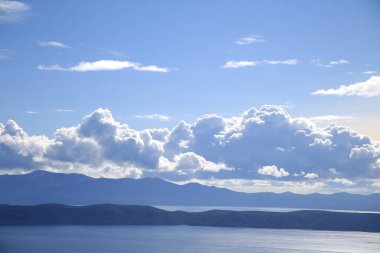 Hırvatistan 'da Adriyatik Denizi üzerindeki mavi gökyüzünde beyaz bulutlar