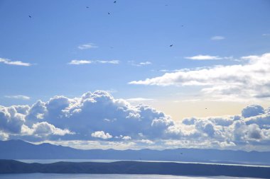 Hırvatistan 'da Adriyatik Denizi üzerindeki mavi gökyüzünde beyaz bulutlar