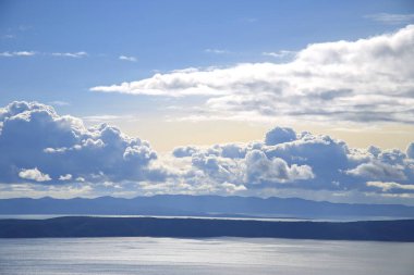 Hırvatistan 'da Adriyatik Denizi üzerindeki mavi gökyüzünde beyaz bulutlar