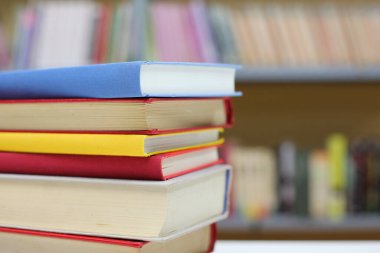 Kütüphanedeki masanın üzerinde kitap yığını