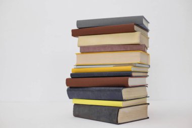 Masanın üzerinde beyaz arkaplanı olan kitaplar