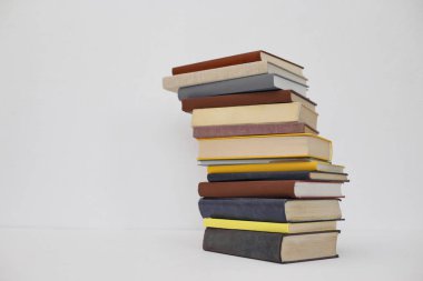 Masanın üzerinde beyaz arkaplanı olan kitaplar