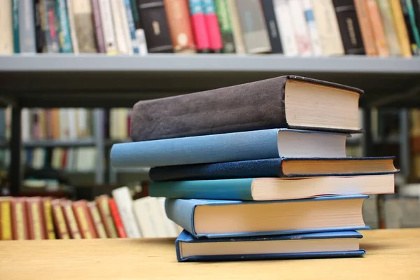 Kütüphanedeki masanın üzerinde kitap yığını