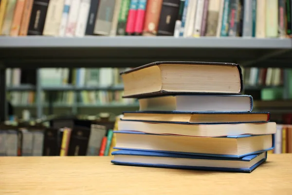 Kütüphanedeki masanın üzerinde kitap yığını