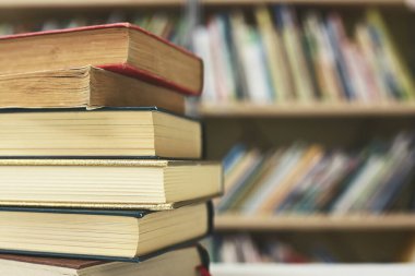 Kütüphanedeki masanın üzerinde kitap yığını