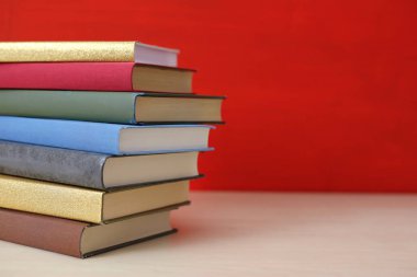 Kırmızı arkaplan üzerine kitap yığını