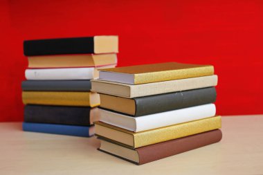 Kırmızı arkaplan üzerine kitap yığını