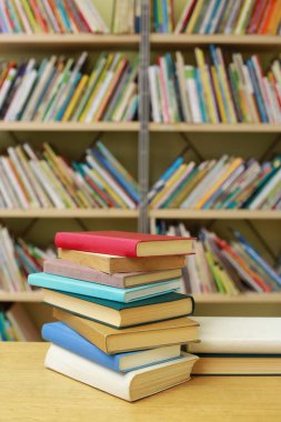 Kütüphanedeki masanın üzerinde kitap yığını