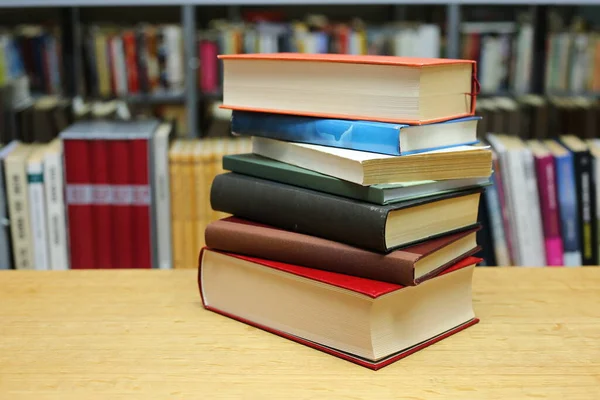 Kütüphanedeki masanın üzerinde kitap yığını