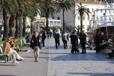 04.02.2020. Makarska, Hırvatistan ve pek çok vatandaş, güneşli Makarska 'da rıhtım boyunca yürümek ve açık havada kalmak için güneşli bir günü kullandı.