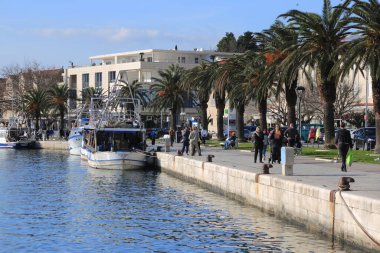 04.02.2020. Makarska, Hırvatistan ve pek çok vatandaş, güneşli Makarska 'da rıhtım boyunca yürümek ve açık havada kalmak için güneşli bir günü kullandı.