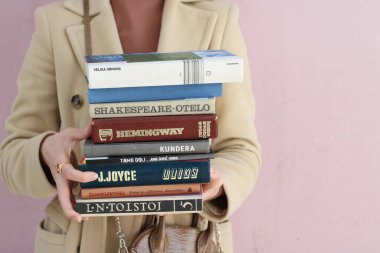 Makarska, Hırvatistan, 01.03.2021. Ünlü yazarlardan Haruki Murakami, Jure Diviç, James Joyce, Ernest Hemingway, Lav, William Shakespeare, Fjodor Dostojevski 'nin kitapları genç bir öğrencinin ellerinde