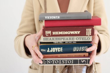 Makarska, Hırvatistan, 01.03.2021. Ünlü yazarlardan Haruki Murakami, Jure Diviç, James Joyce, Ernest Hemingway, Lav, William Shakespeare, Fjodor Dostojevski 'nin kitapları genç bir öğrencinin ellerinde