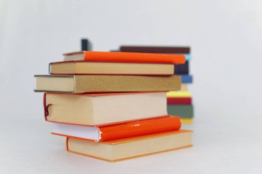 Beyaz arkaplanda bir yığın turuncu kitap