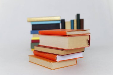 Beyaz arkaplanda bir yığın turuncu kitap
