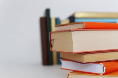 Beyaz arkaplanda bir yığın turuncu kitap