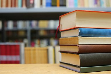 Kütüphanedeki masanın üzerinde kitap yığını