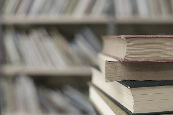 Kütüphanedeki masanın üzerinde kitap yığını